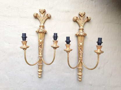 Ornate vintage brass wall lamp with two arms and a detailed gold finish