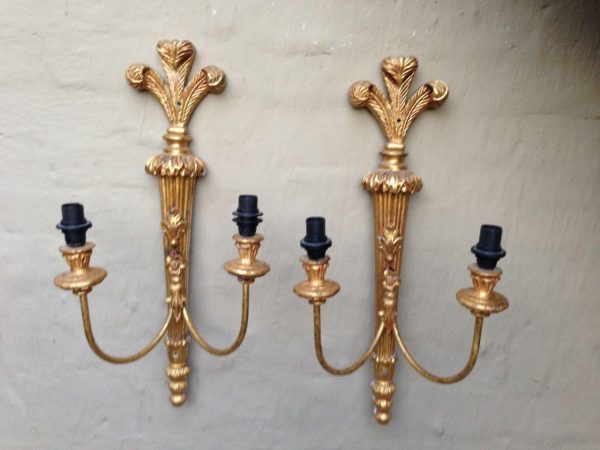 Ornate vintage brass wall lamp with two arms and a detailed gold finish