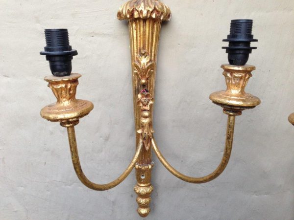 Ornate vintage brass wall lamp with two arms and a detailed gold finish