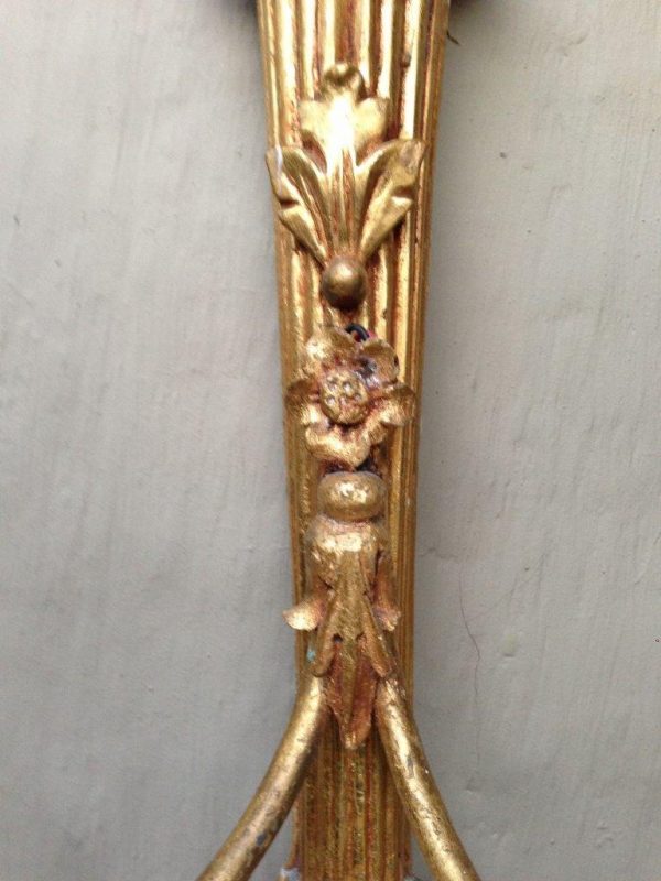 Ornate vintage brass wall lamp with two arms and a detailed gold finish
