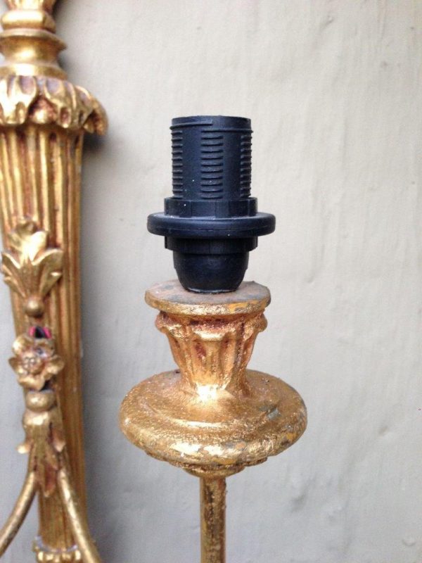 Ornate vintage brass wall lamp with two arms and a detailed gold finish