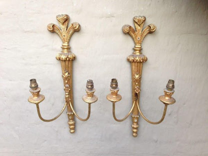Ornate vintage brass wall lamp with two arms and a detailed gold finish