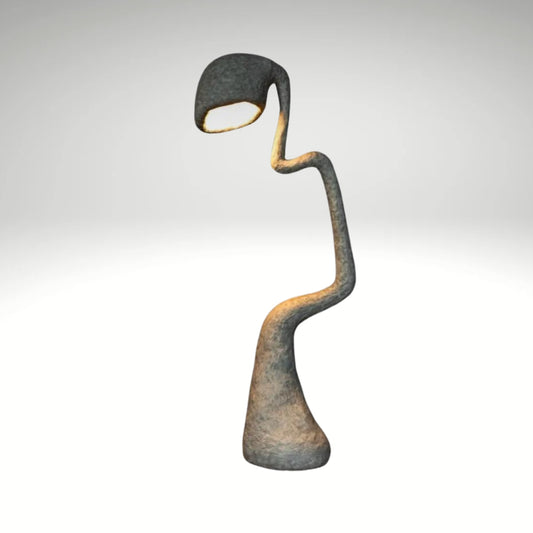 A modern floor lamp with a textured finish and a sculptural, serpentine curved body emitting a warm downlight