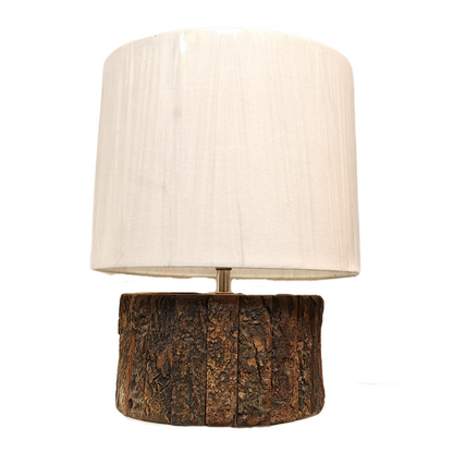 A bohemian-style desk lamp crafted from a blocky, distressed wood baluster and a natural straw woven shade.
