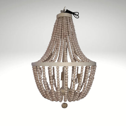 A rustic boho chandelier made of cascading strands of white wooden beads hung from a circular metal frame.