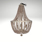 A rustic boho chandelier made of cascading strands of white wooden beads hung from a circular metal frame.
