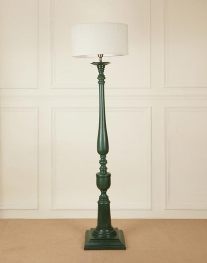 A classic forest green wooden floor lamp with an ornate carved pillar base and neutral shade.