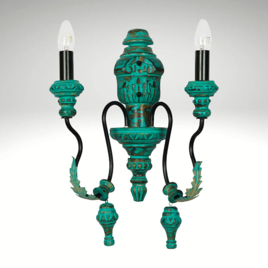 Classic 2-light wall sconce with a distressed turquoise and gold patina finish, black curved arms, and candle-style bulbs.