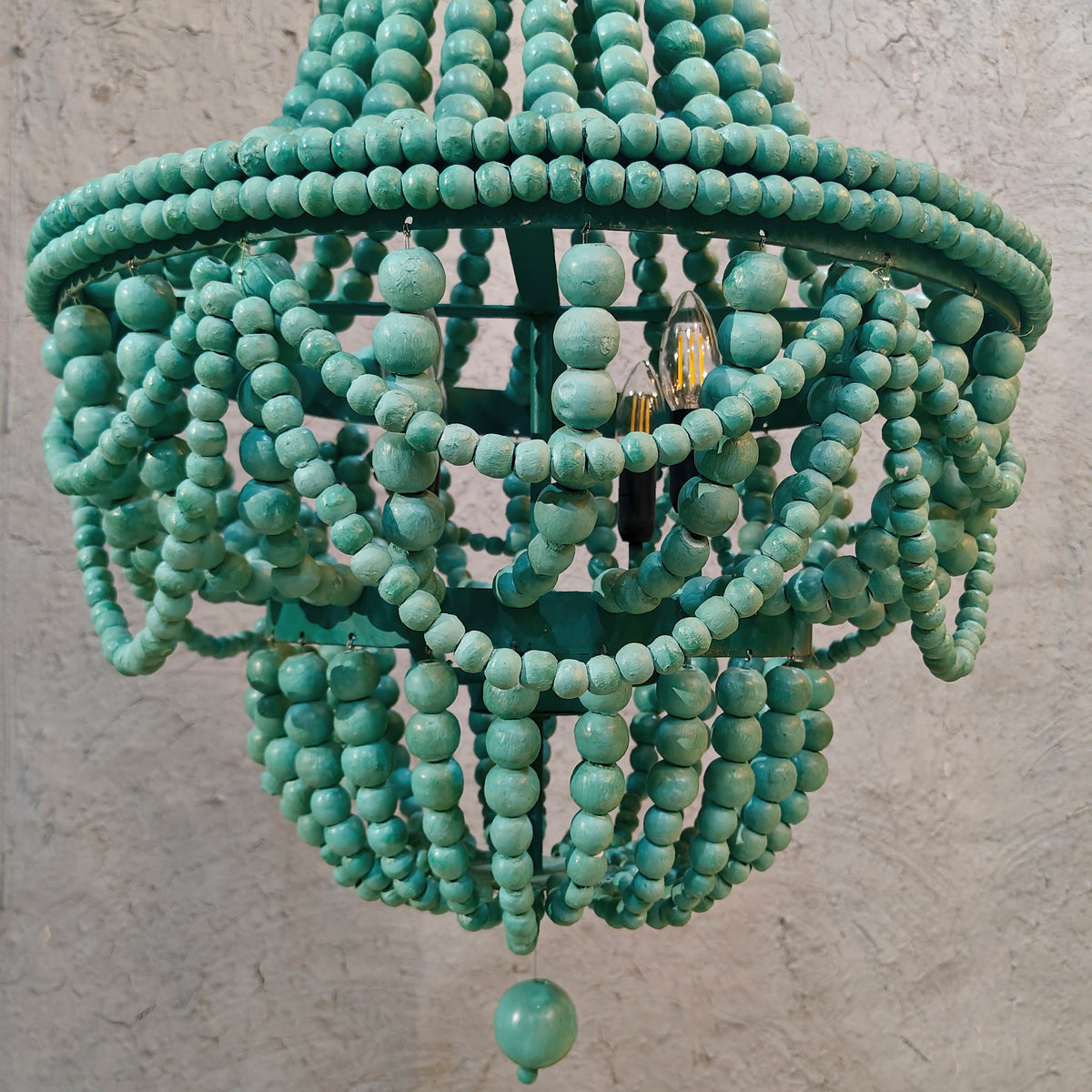 An empire-style chandelier crafted from vibrant green wooden beads
