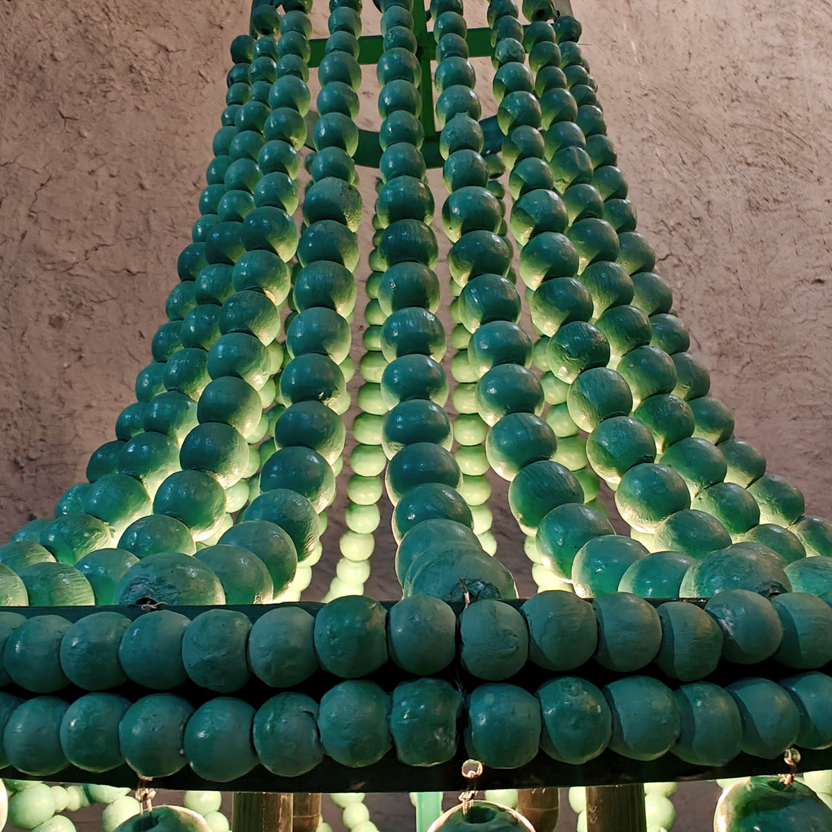 An empire-style chandelier crafted from vibrant green wooden beads