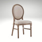 A rustic French country dining chair featuring an oval upholstered backrest and a weathered wooden frame.