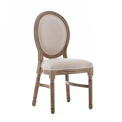 A rustic French country dining chair featuring an oval upholstered backrest and a weathered wooden frame.