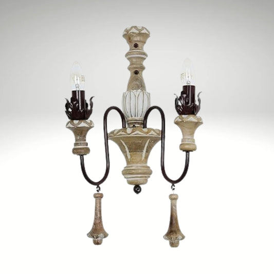 Antique-style double candle wall lamp made of carved distressed wood and curved metal accents.