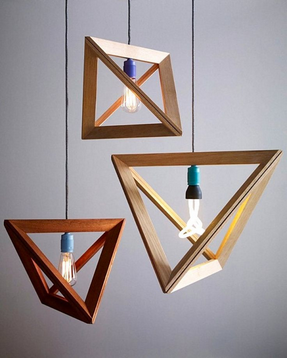 A minimalist pyramid-shaped wooden hanging lamp with a warm glowing light bulb.