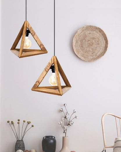 A minimalist pyramid-shaped wooden hanging lamp with a warm glowing light bulb.