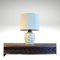 Modern table lamp with a textured mosaic pattern base and a pleated white lampshade