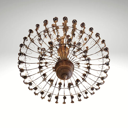 An antique bronze finish round chandelier featuring detailed leaf patterns, multiple small light bulbs, and a radial cage design.