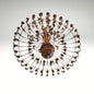 An antique bronze finish round chandelier featuring detailed leaf patterns, multiple small light bulbs, and a radial cage design.