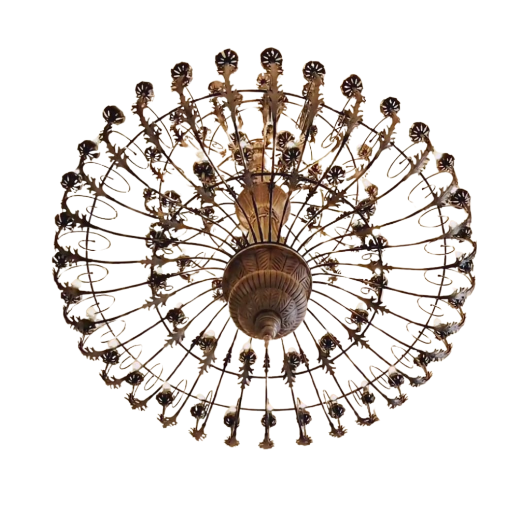 An antique bronze finish round chandelier featuring detailed leaf patterns, multiple small light bulbs, and a radial cage design.