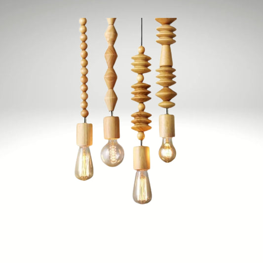 Four hanging pendant lights with light-colored, decorative turned wood beads covering the cords and exposed Edison bulbs.