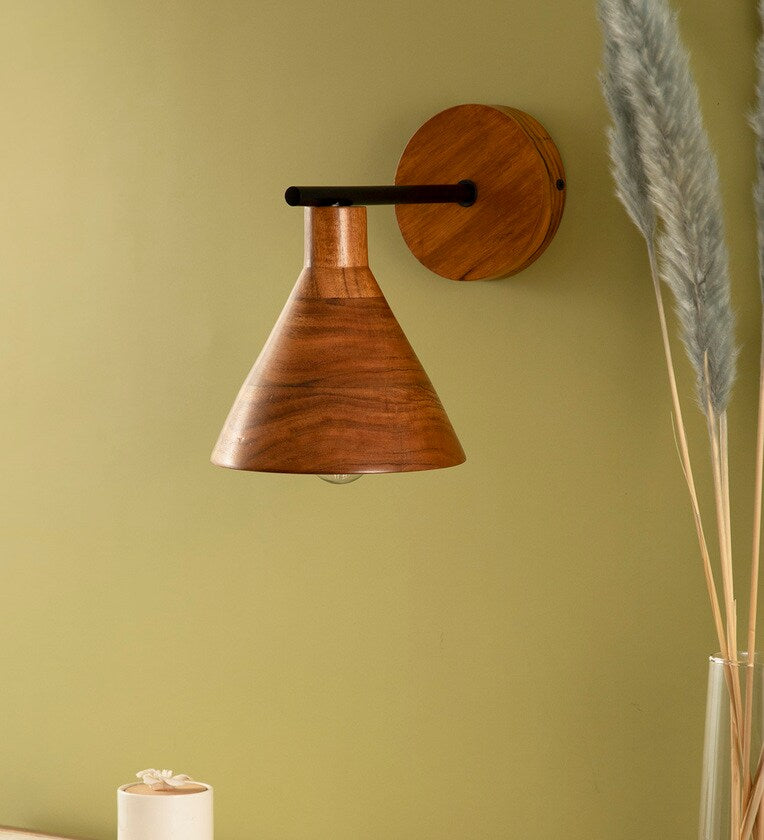 • Mid-century modern style wall lamp with a tapered warm-toned wood shade and a matching circular backplate connected by a minimal black metal bar.
