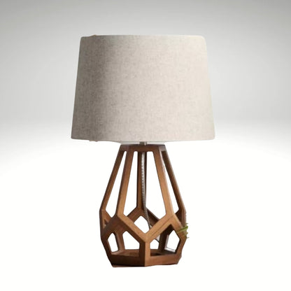 A modern table lamp featuring a brown geometric hollow wood base and a light beige fabric drum shade.