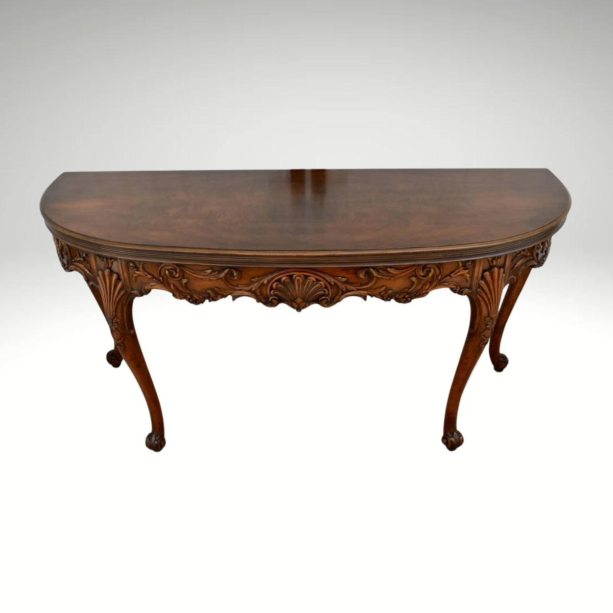 Vintage carved wooden half-moon console table with ornate details and curved legs.