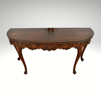 Vintage carved wooden half-moon console table with ornate details and curved legs.