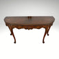 Vintage carved wooden half-moon console table with ornate details and curved legs.