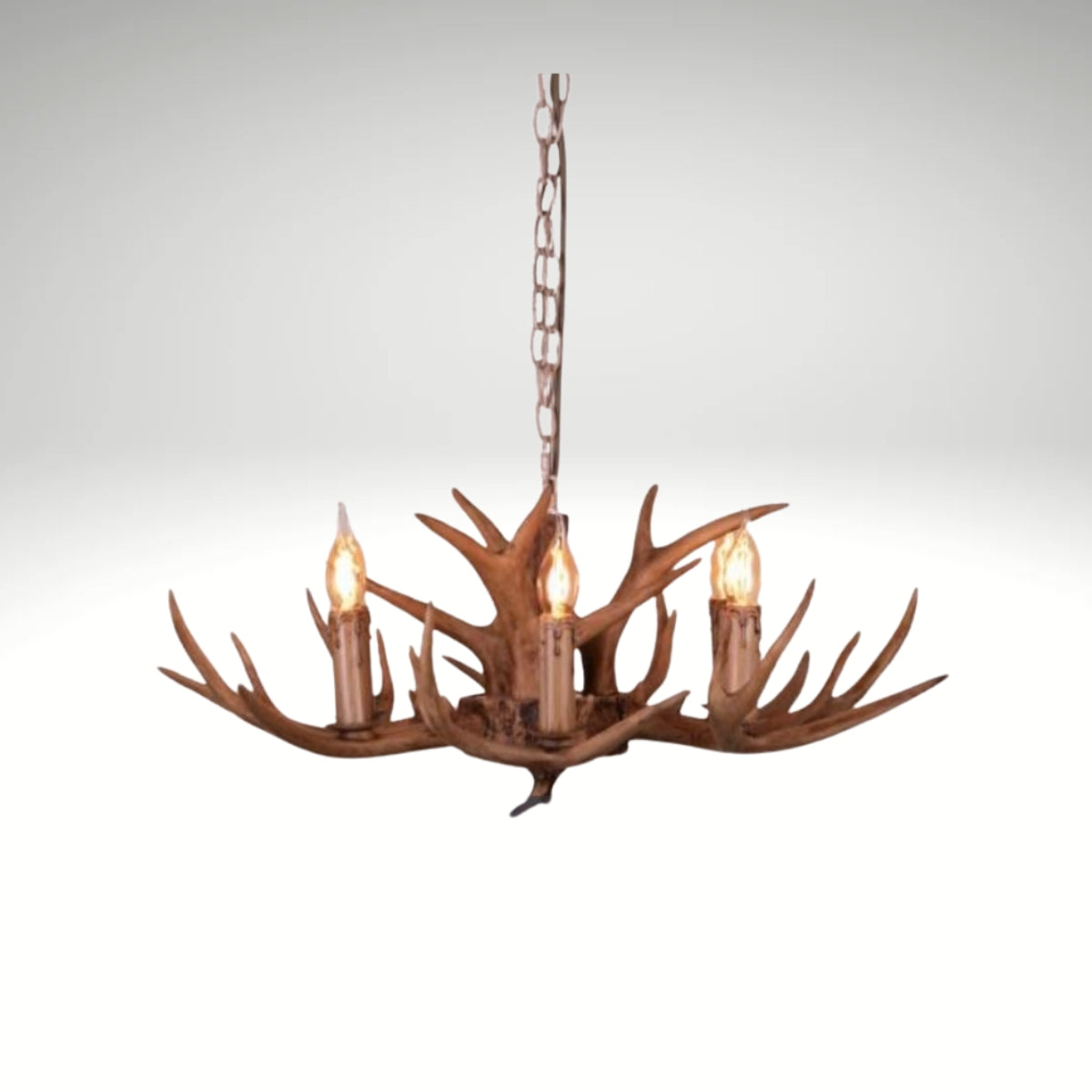 Faux antler pendant light with three lit candle-style bulbs, country style design.
