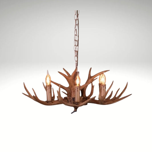 Faux antler pendant light with three lit candle-style bulbs, country style design.