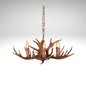 Faux antler pendant light with three lit candle-style bulbs, country style design.