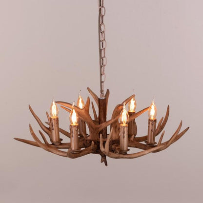 Faux antler pendant light with three lit candle-style bulbs, country style design.