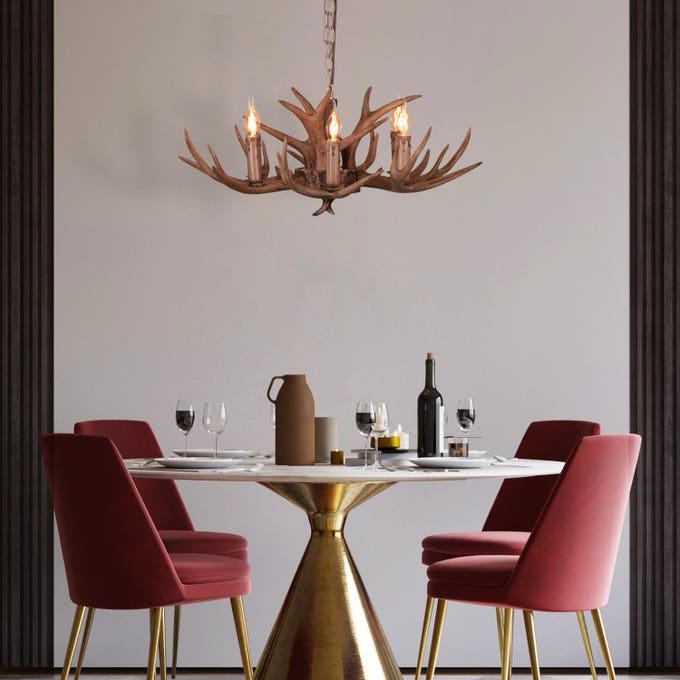 Faux antler pendant light with three lit candle-style bulbs, country style design.