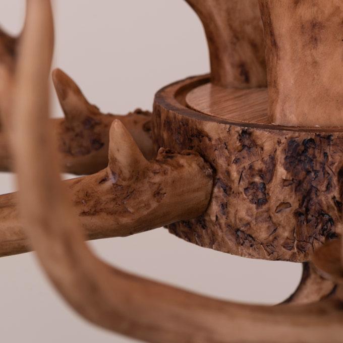 Faux antler pendant light with three lit candle-style bulbs, country style design.