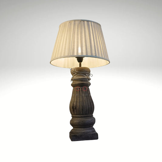 Rustic turned wood table lamp with a pleated cream fabric shade.