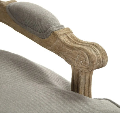 A classic French country style armchair with a weathered natural wood frame and comfortable grey linen upholstered cushions.