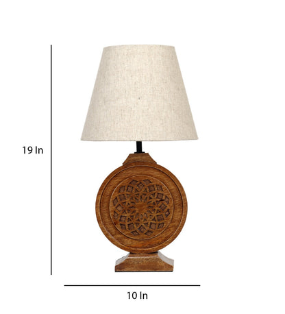 Bohemian-style table lamp with a round, carved wood mandala base and a neutral fabric lampshade