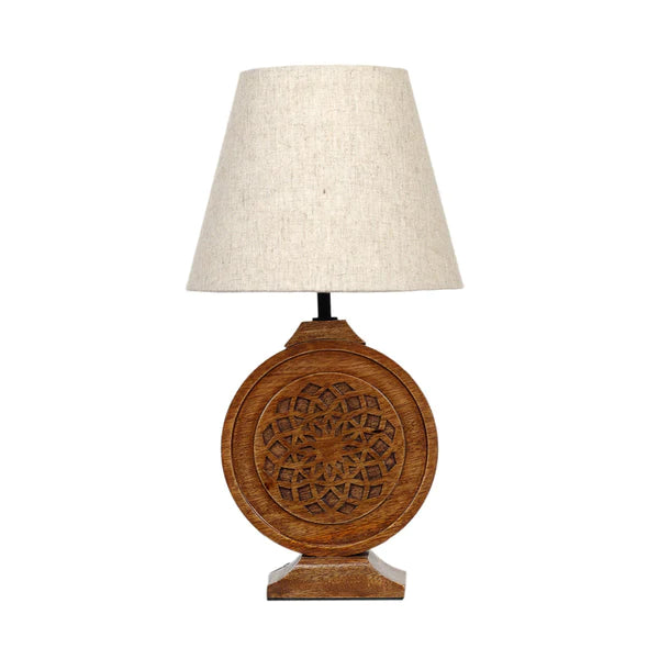 Bohemian-style table lamp with a round, carved wood mandala base and a neutral fabric lampshade