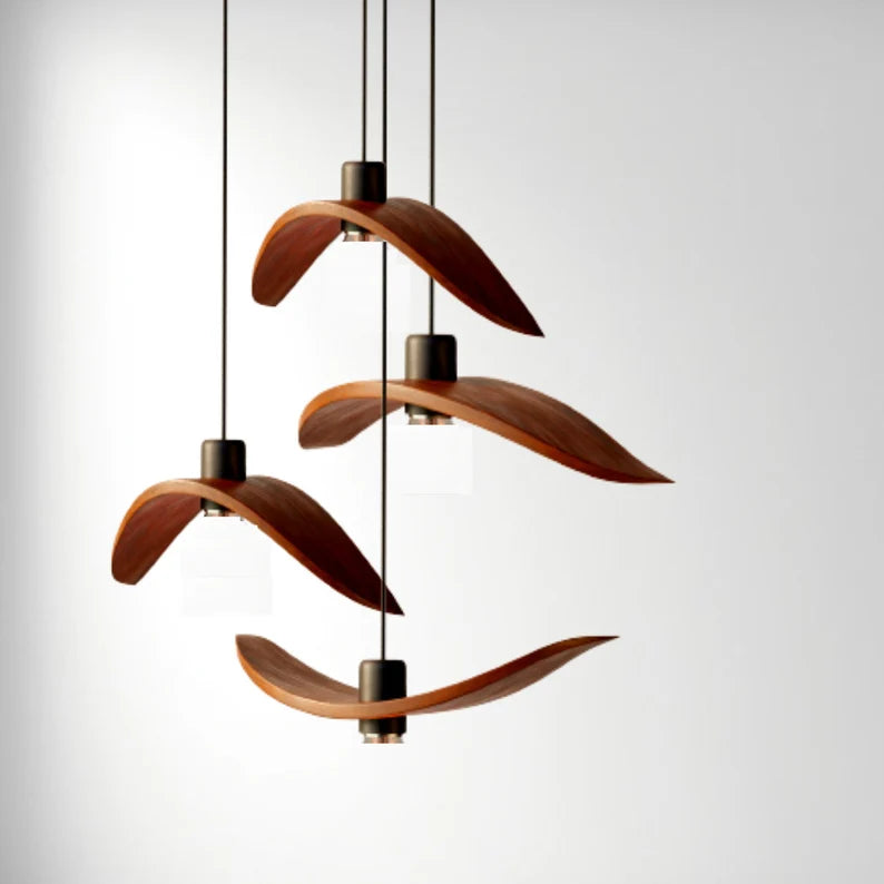Minimalist Scandinavian ceiling chandelier featuring four bird-wing-shaped natural wood shades dangling at adjustable heights.