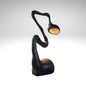 Biomorphic black floor lamp featuring a curved snake-like body and warm internal glow.