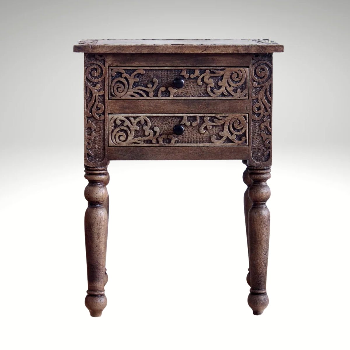 Traditional brown wooden side table featuring intricate floral carvings on two drawers.