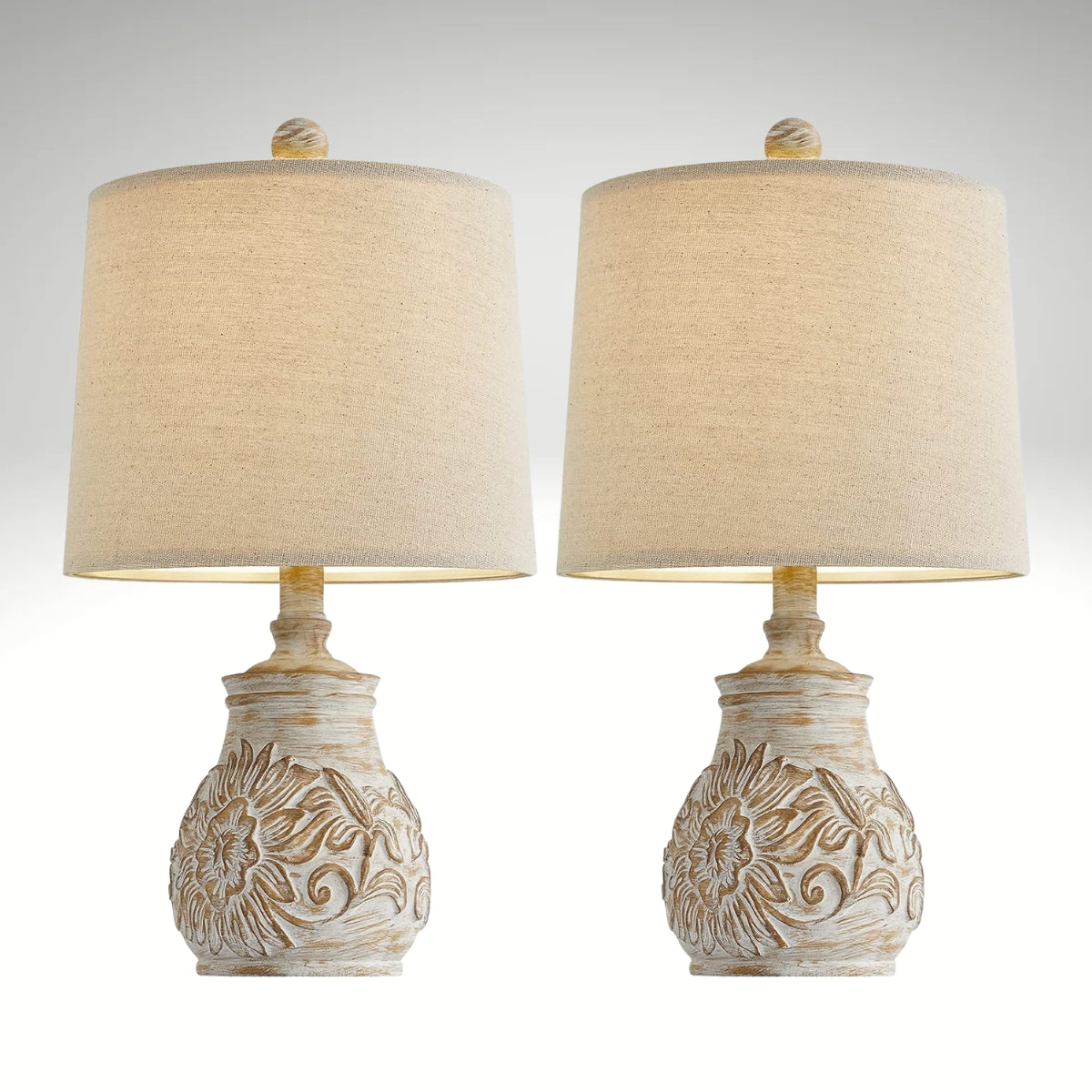 Distressed white ceramic table lamp with a carved sunflower base and a beige fabric drum shade.