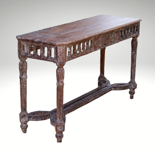 Rustic hand-carved solid wood console table with a weathered finish, standing outdoors on a stone and dirt path.
