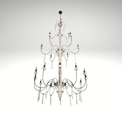 A multi-tiered rustic white chandelier with distressed wood columns and black iron scrolled arms.