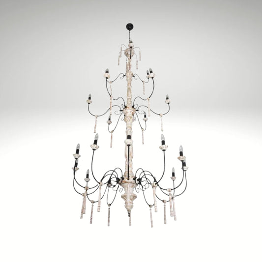 A multi-tiered rustic white chandelier with distressed wood columns and black iron scrolled arms.