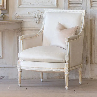 Vintage-style cream accent armchair with a padded seat and backrest.