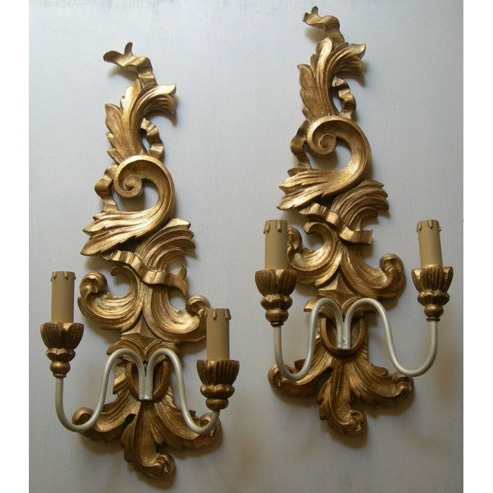 Ornate gold baroque wall sconce with a dual candle light fixture.
