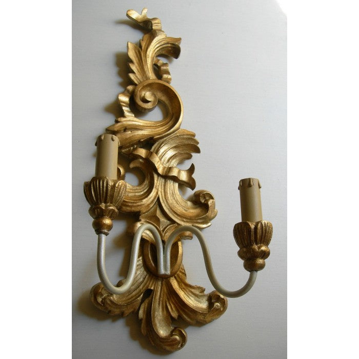Ornate gold baroque wall sconce with a dual candle light fixture.
