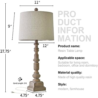 A traditional table lamp featuring a distressed, turned-wood candlestick base and a neutral beige fabric drum shade